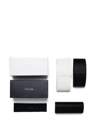 Due custodie per occhiali Prada in pelle traforata nera e bianca con scatole abbinate in nero e bianco con marchio e un panno per la pulizia nero.