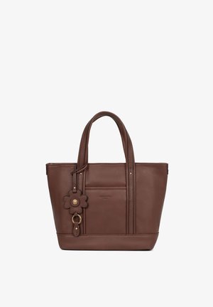 Sac cabas en cuir marron avec doubles poignées et un pendentif en forme de fleur attaché à une des poignées.