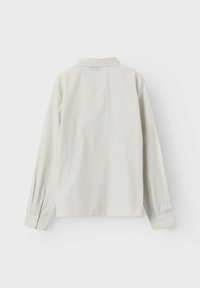 Camicia a maniche lunghe a righe in colori chiari con polsini abbottonati. Il design presenta un colletto e righe verticali di larghezze variabili.