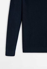 Laivastonsininen neulepaita, jossa on sileä tekstuuri ja istuvat hihat. Siinä on suora helma ja resorit hihansuissa.