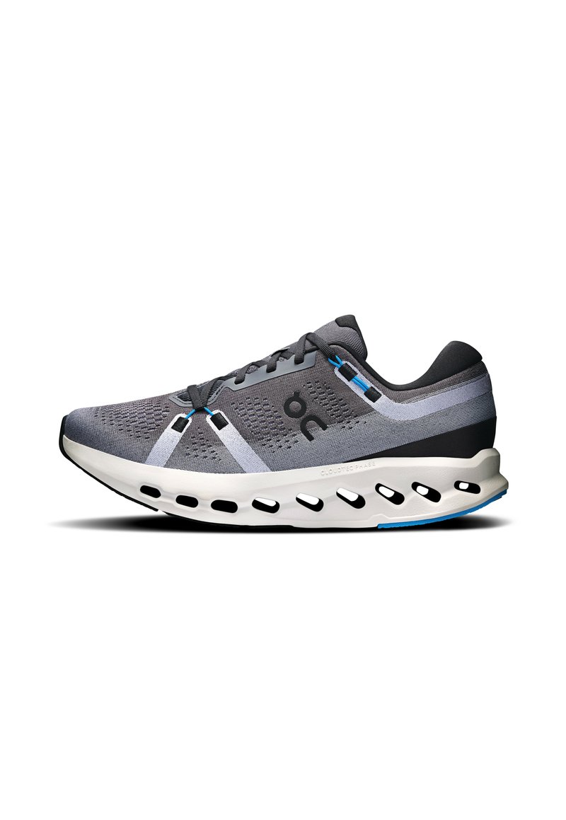 Zapatilla deportiva gris con parte superior de malla, acentos en capas en gris y negro, una entresuela blanca acolchada y un diseño de suela recortado único.