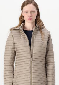 Beige Puffer-Jacke mit horizontalen Steppmustern, Frontreißverschluss und Kapuze. Glattes, leichtes Material mit taillierter Silhouette.