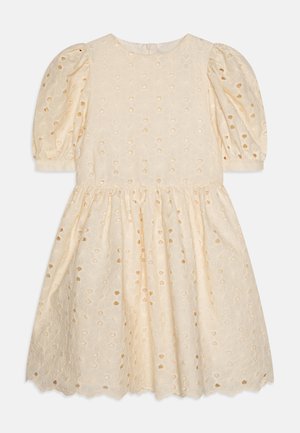 Robe crème légère avec des manches bouffantes, des motifs floraux brodés et des détails découpés. Ourlet festonné et encolure ronde.