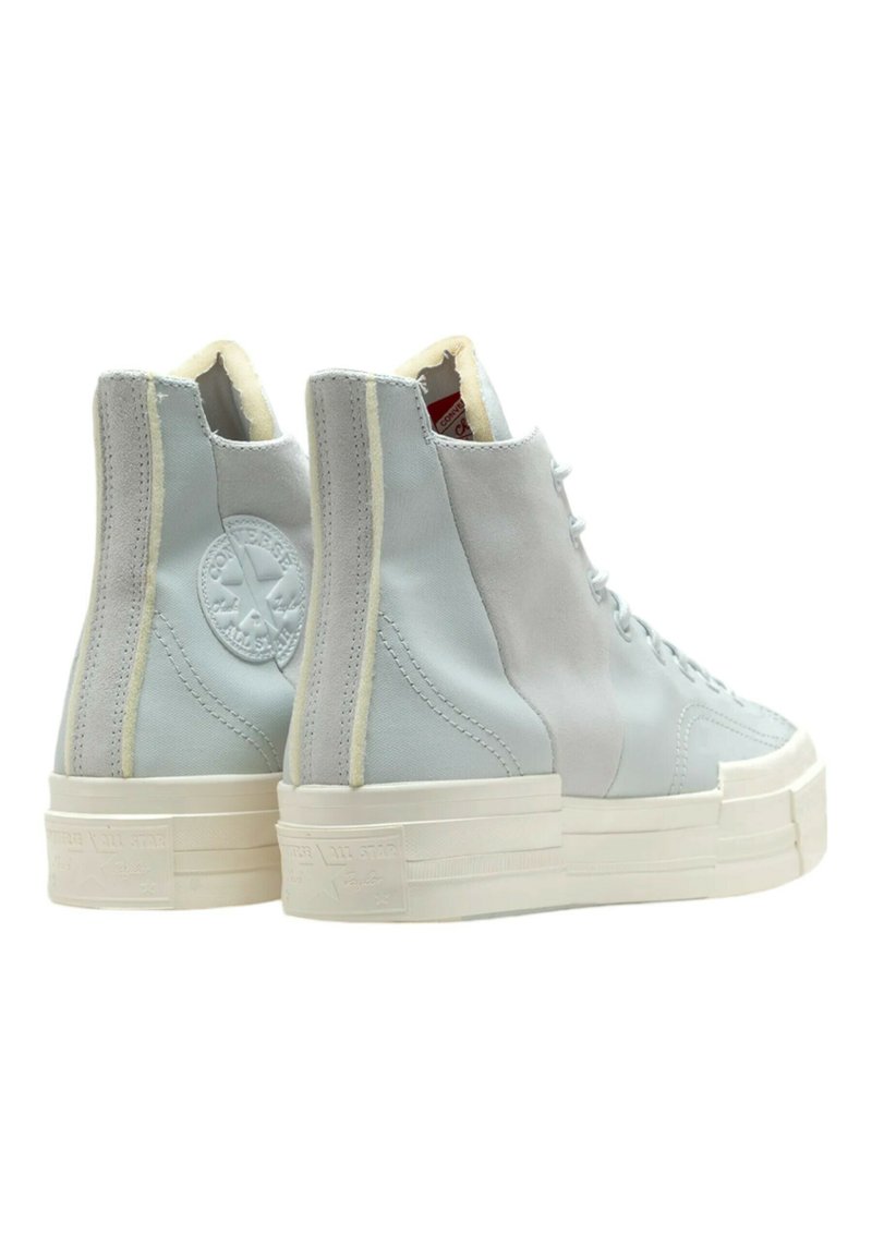 Zapatillas altas en ante y lona de color azul claro con suela de goma blanca. Presentan un logo en el lateral y acentos de costura blanca.