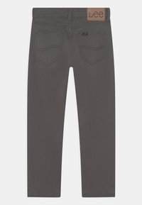 Jeans de mezclilla gris con un diseño de pierna recta. Presenta un parche de cuero con el logo y dos bolsillos traseros con costuras decorativas.
