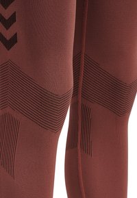 Hoge prestaties leggings in diep bordeauxrood met getextureerde zwarte accenten en stijlvolle patronen. Voorzien van een soepele, elastische stof voor comfort.
