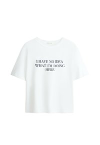 T-shirt blanc à manches courtes avec un texte noir centré indiquant : « JE N'AI AUCUNE IDÉE DE CE QUE JE FAIS ICI. »