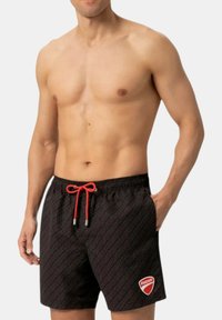 Pantaloni da nuoto neri con motivo di logo ripetuto, cordino rosso e estremità argentate. Presenta un logo rosso Ducati sulla gamba sinistra.