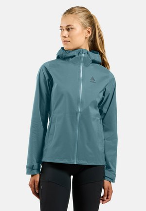 Veste légère teal avec capuche, fermeture éclair intégrale et poignets élastiques. Fabriquée en matériau résistant à l'eau, avec un logo sur la poitrine.