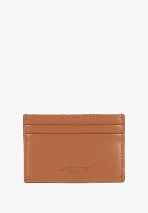 Tan leather card holder with four card slots, embossed logo at the bottom, smooth texture, and clean, minimalistic design.