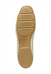 Zapatilla blanca con una suela de goma marrón que presenta perforaciones para la transpirabilidad y patrones de agarre texturizados. Logotipo impreso en la suela.