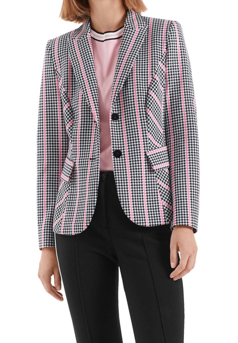 Sort og hvid houndstooth blazer med pink striber, enkeltknap design, to frontlommer og spidse lapeller. Kombineret med en pink top.