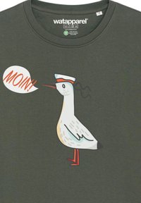 Donkergroen T-shirt met een cartoonzeemeeuw die een zeeman muts draagt, met de spraakbel "MOIN!" in het oranje. Soepele textuur.