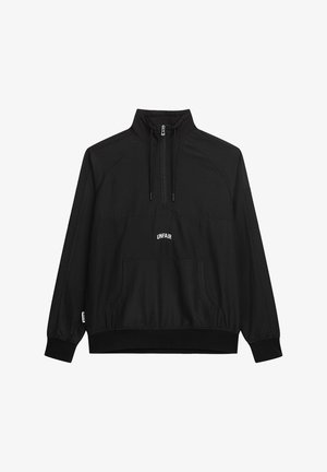 Schwarzer Pullover-Sweatshirt, mit Reißverschluss am Stehkragen, elastischen Bündchen, vorderer Kängurutasche, weißem "UNFAIR"-Logo auf der Brust, glatte Stoffoberfläche.