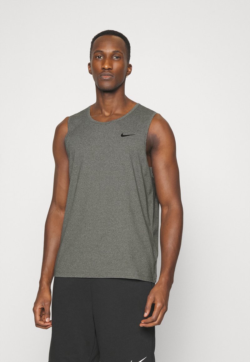 Grå ermeløs treningstrøye laget av pustende stoff, med rund halslinning og en liten svart Nike-logo på brystet.