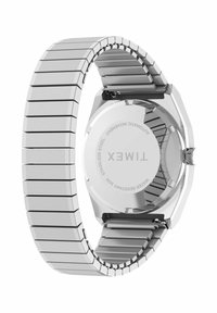 Montre automatique en acier inoxydable avec un boîtier hexagonal, un bracelet maillon, une finition polie et des détails gravés au dos du boîtier. Résistante à l'eau jusqu'à 50 mètres.