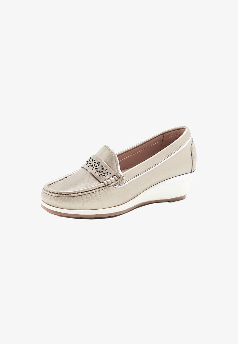 Mocassin en cuir beige avec un bout arrondi, découpes décoratives sur le devant et un talon en wedge blanc. Texture lisse avec des détails cousus.