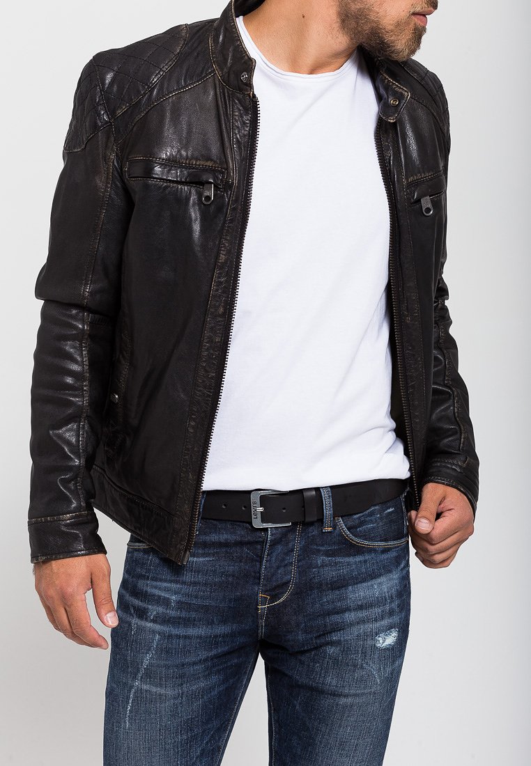 Black leather jacket with quilted shoulder detailing, zippered pockets, and a casual fit, worn over a white shirt and blue jeans.