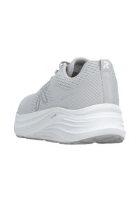 Chaussure de sport gris clair avec tige en mesh, motif texturé et semelle blanche amortissante. Présente un logo sur le talon et le côté latéral.