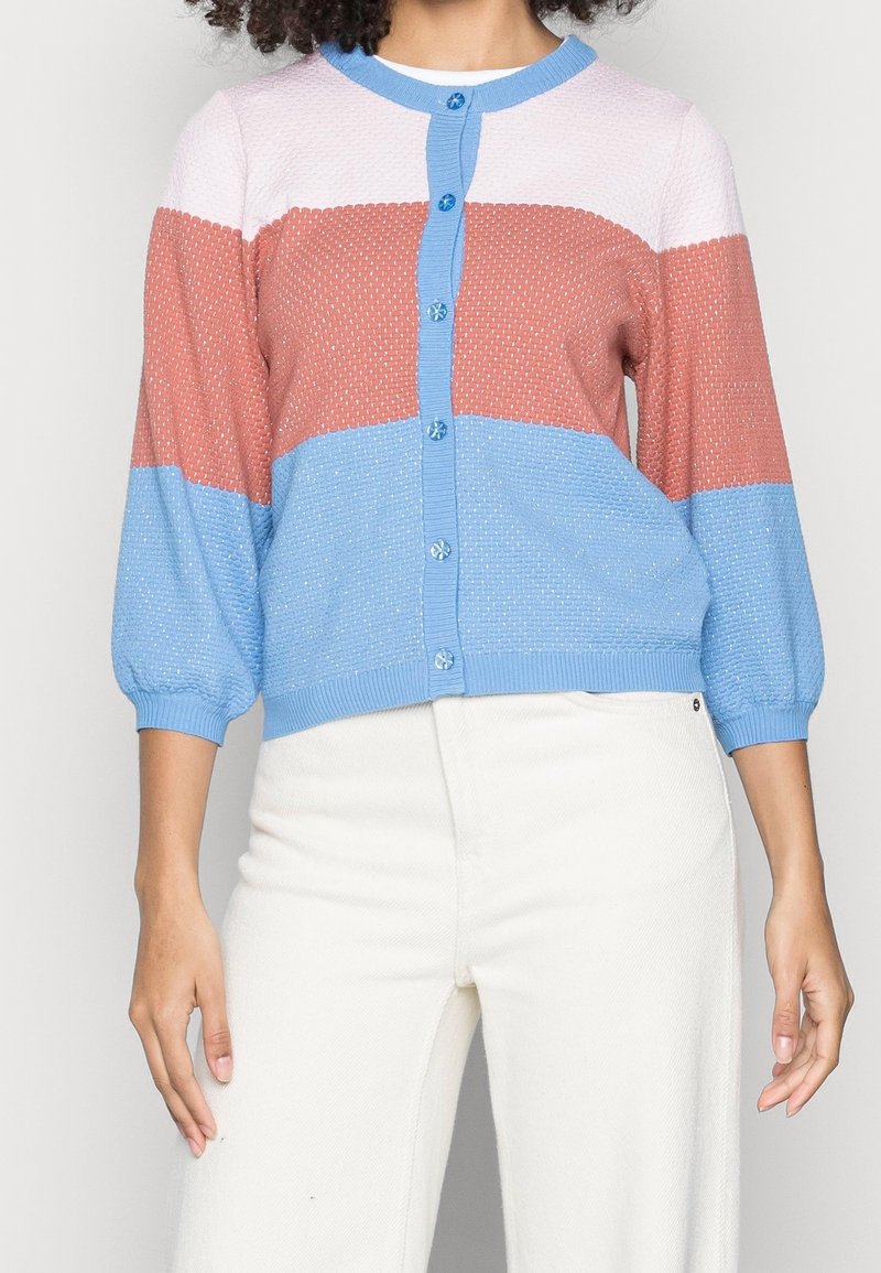 Knitted cardigan featuring a color-block design in pink, coral, and blue with three-quarter puff sleeves and round neckline, secured by button closure.