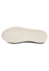Semelle de chaussure en caoutchouc blanc avec un motif texturé comportant des triangles et des rainures pour l'adhérence ; inclut un logo partiel près de la zone du talon.