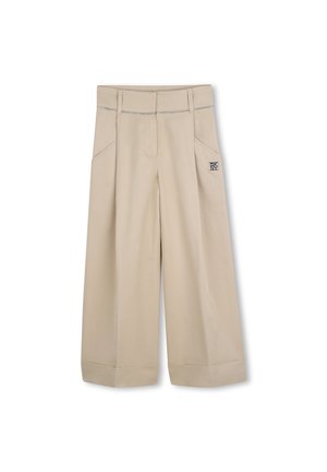 Beige wide-leg pants with front pockets, folded hems, and contrast stitching. Features logo patch on the side near the waistband.