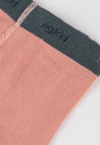 Calzini rosa chiaro con un polsino a coste grigio scuro. Il tessuto sembra morbido ed elastico, con dettagli di cucitura visibili e un'etichetta del marchio.