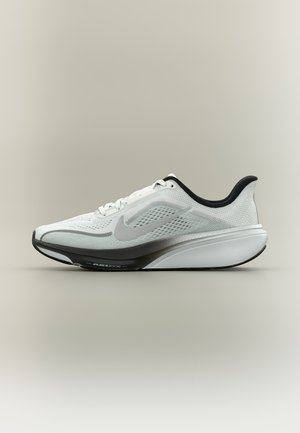 Zapatilla de correr ligera en blanco y negro con parte superior de malla y suela acolchada que presenta la tecnología visible Air Zoom.