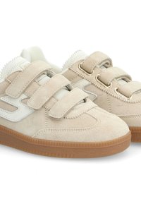 Baskets en suède beige avec des accents blancs, dotées de trois bandes auto-agrippantes et d'une semelle en caoutchouc texturé marron. Design à bout arrondi.