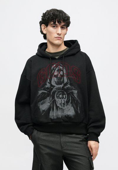 Hanorac negru cu glugă, prezentând un design grafic mare în nuanțe de gri și roșu, reprezentând o figură cu un craniu, cu șnururi și detalii cu tiv elastic.