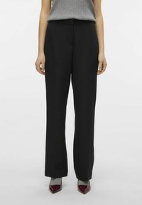 Svart, høy midje bukser med en rett ben-design. Glatt stoff med en skreddersydd silhuett, kombinert med spisse burgunder hæler.