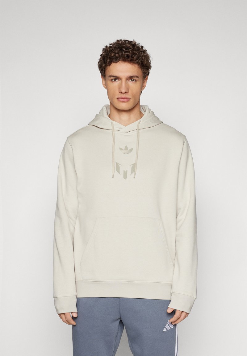 Helle beige Kapuzenpullover mit Kängurutasche, verstellbarem Kordelzug und einem dezenten Logo in der Mitte. Weicher Stoff und lockere Passform.