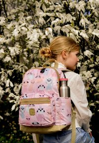 Roze stoffen rugzak met dierenpatronen, voorzak met rits, beige onderkant en zijvak met een roestvrijstalen waterfles.