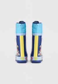 Botas de lluvia de goma azules con rayas amarillas, un puño superior azul y gráficos de dibujos animados de animales con acentos de huellas en la suela.