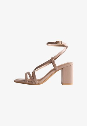 Beige hoge hak sandaal met een robuuste blokhak, een gestructureerd ontwerp, enkelgesp en een gladde, glanzende afwerking op het bovenmateriaal.