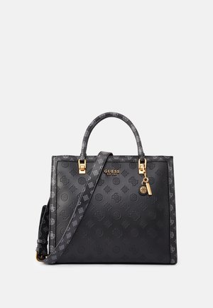 Zwarte Guess-handtas met reliëf logo patroon, goudkleurige hardware, bovenhandvatten en afneembare schouderriem op een effen achtergrond.