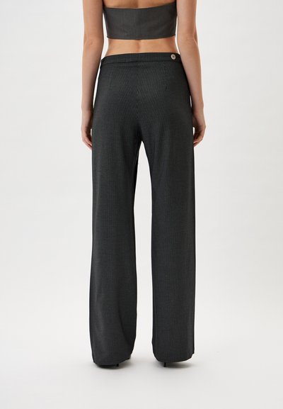 Black and white striped wide-leg trousers with a high waist, featuring a button closure and soft fabric texture.