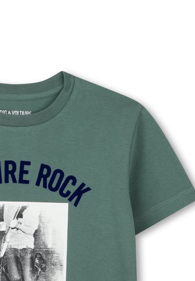 Groene katoenen T-shirt met "ROCK" in donkerblauwe letters, met een afbeelding van een persoon die een gitaar vasthoudt, gedrukt op de voorkant.