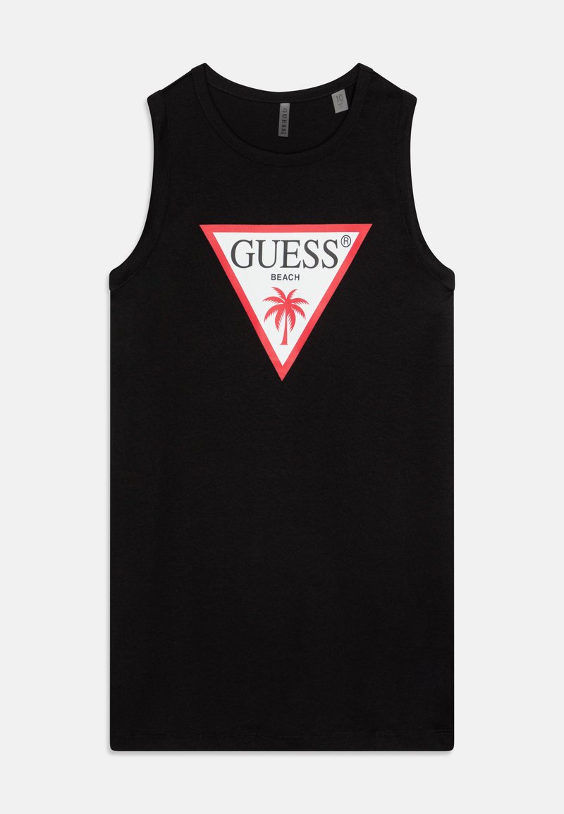 Juodas be rankovių marškinėliai, pagaminti iš medvilnės, su dideliu baltu ir raudonu trikampio logotipu, kuriame užrašyta "GUESS BEACH" ir palmės grafika.