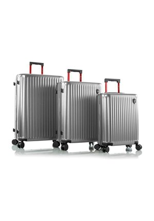 Three silver hard-shell suitcases with red handles and black wheels, arranged in descending size from left to right on a white background.