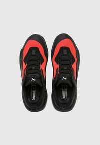 Czarno-czerwone buty sportowe z siateczkową cholewką, wyściółką przy kostce, grubą podeszwą i systemem sznurowania. Logo Puma widoczne na języku i boku.