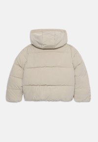 Chaqueta tipo puffer beige con capucha, que presenta un diseño acolchado, puños elásticos y una silueta amplía y cuadrada. Textura suave y ligera.