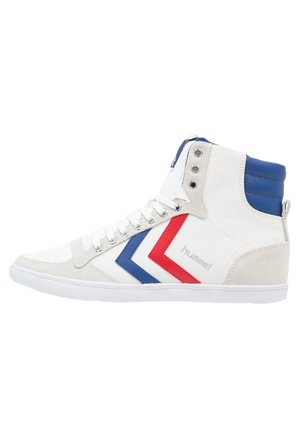 Baskets montantes blanches avec bandes en chevron bleu et rouge, lacets blancs, col rembourré bleu, et logo "hummel" sur le côté.