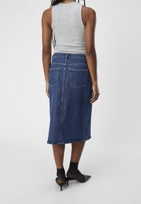 Gonna di jeans con lunghezza midi, lavaggio blu scuro, tasche posteriori e una leggera forma a A completata da una finitura liscia.