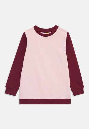 Pull à manches longues avec un devant rose et des manches bordeaux. Doté d'un col côtelé et de poignets, fabriqué en tissu doux.