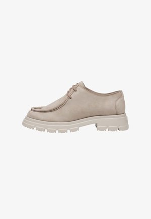 Chaussure en cuir beige à lacets avec semelle épaisse et texturée et bout arrondi, vue de profil sur fond blanc.