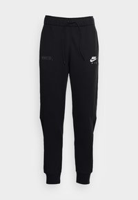 Svarta Nike-joggers i mjukt material, med dragsko i midjan, sidopaneler i mesh och vita logodetaljer på framsidan.