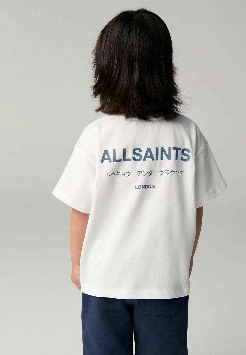 Bílý bavlněný tričko s krátkým rukávem, s námořnickým potiskem "ALLSAINTS" a "LONDON" na zadní straně. Hladká textura, uvolněný střih.