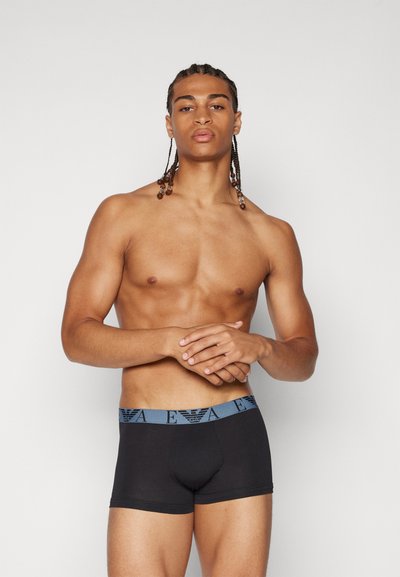 Boxer briefs negros con una cinturilla azul que presenta un patrón de logotipos. El tejido parece suave y elástico, diseñado para mayor comodidad y ajuste.