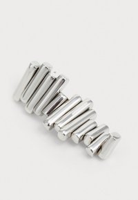 Pinza de pelo plateada que presenta formas cilíndricas alargadas; acabado metálico brillante con una textura suave y longitudes variables.